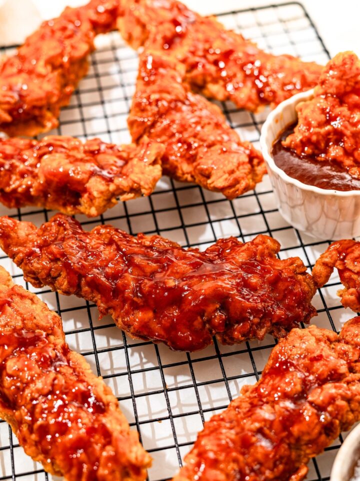 A bunch of honey bbq chicken tenders on a wire rack.