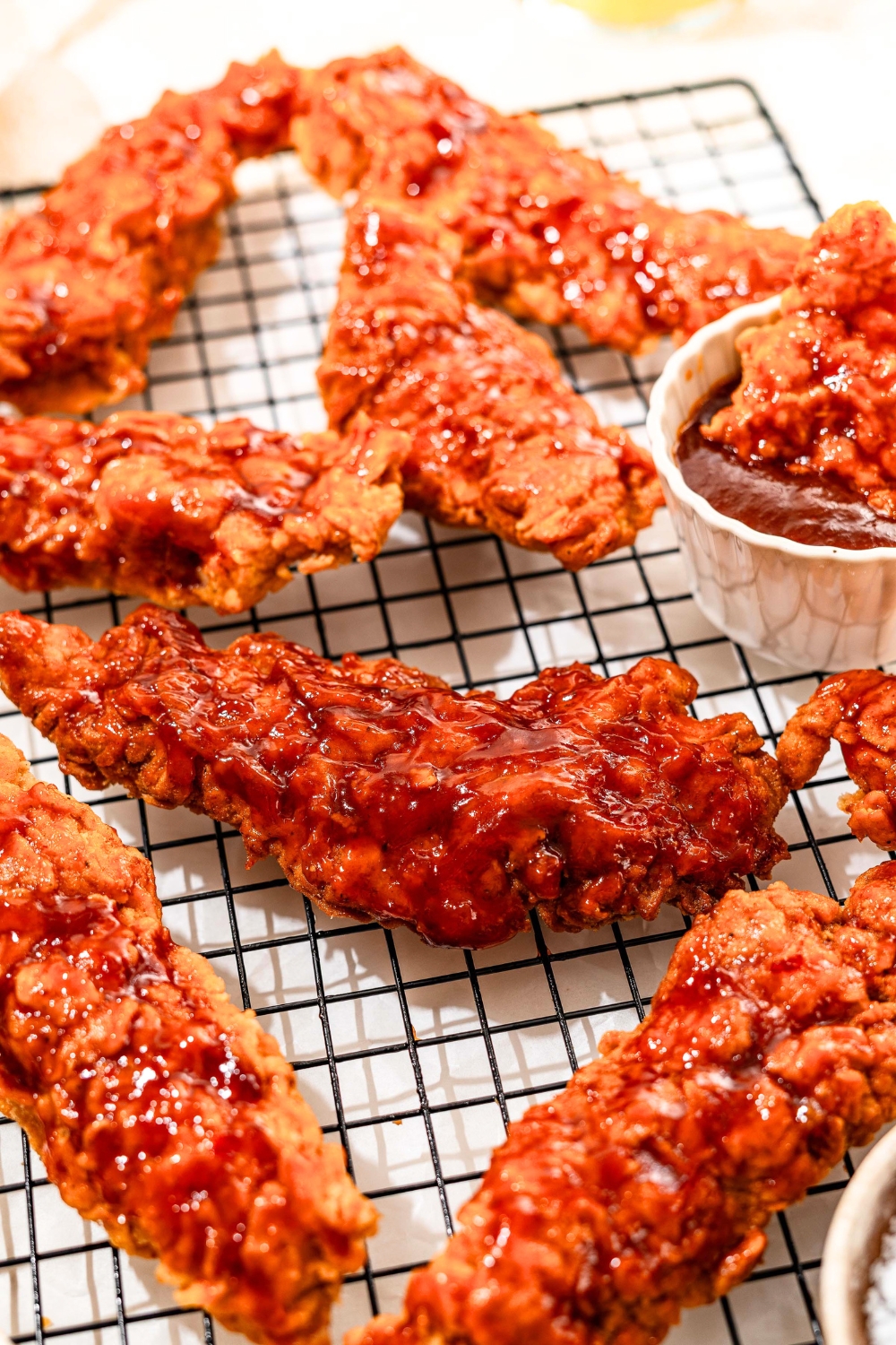 A bunch of honey bbq chicken tenders on a wire rack.