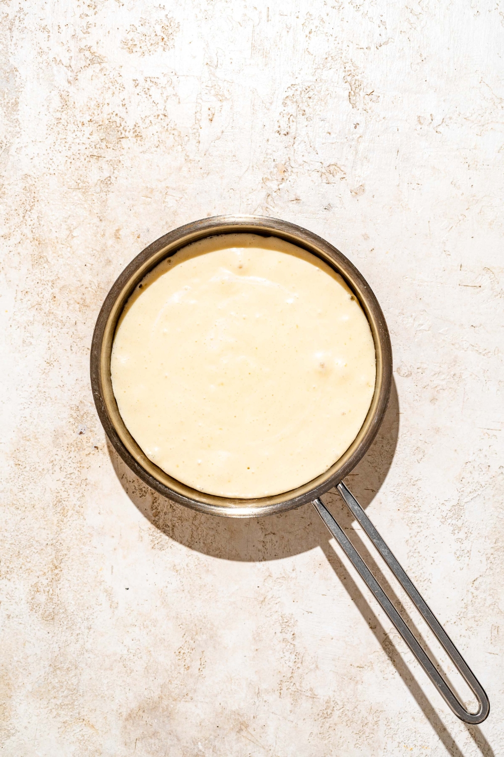 A skillet with pancake batter in it to make golden diner pancakes.