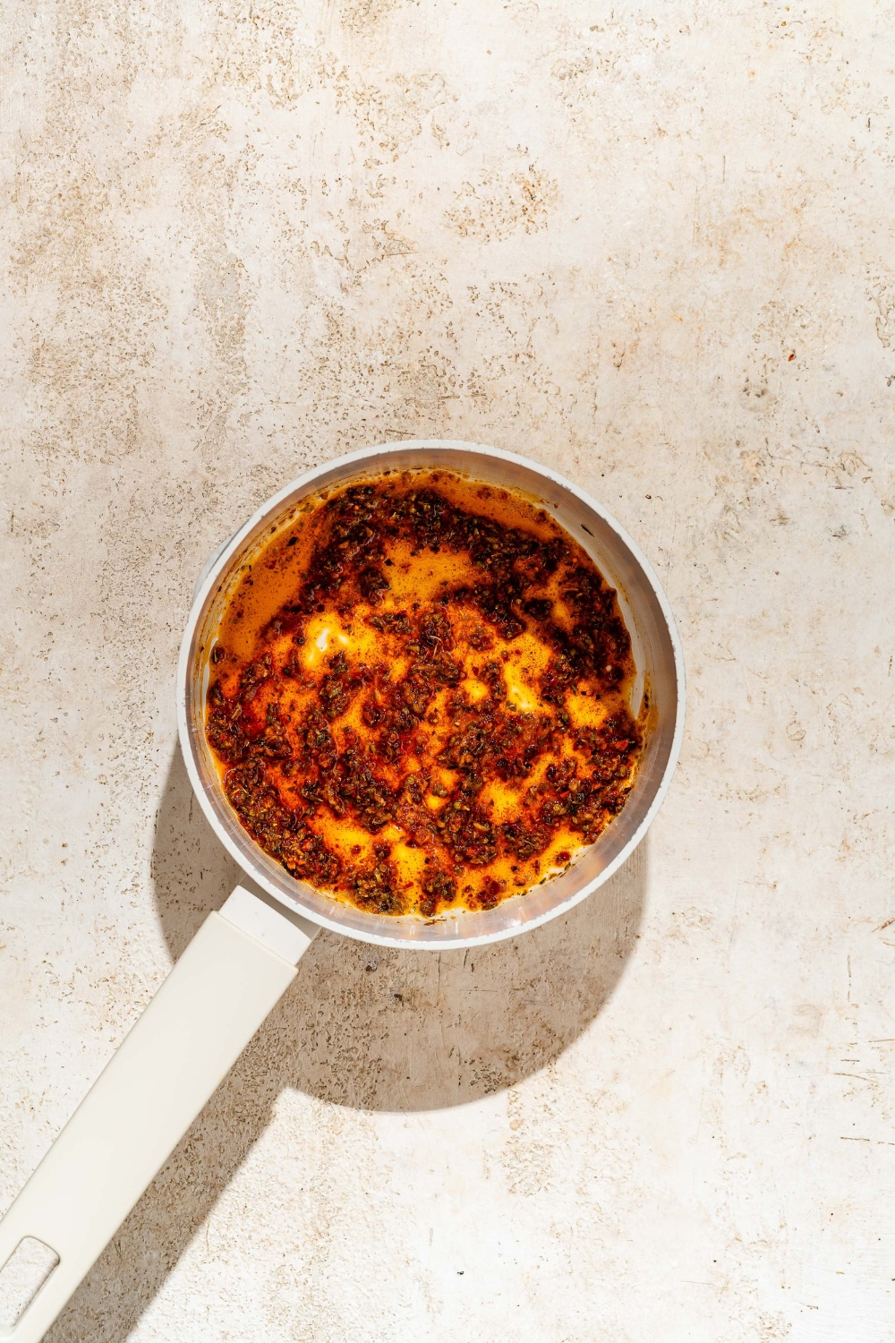 A pot filled with a spice mixture for Peri Peri layers.