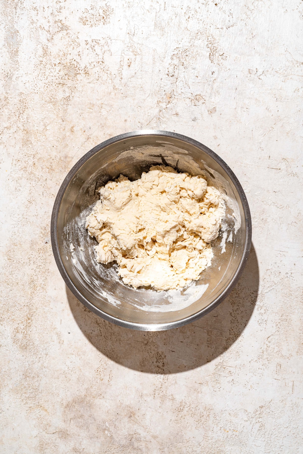 A large bowl with mixed Indian fry bread dough. The bowl is on a tan counter.