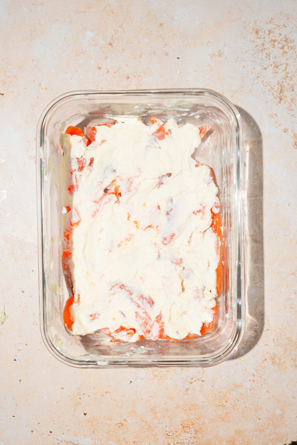 A baking dish with smoked salmon and cream cheese. The dish is on a tan counter.
