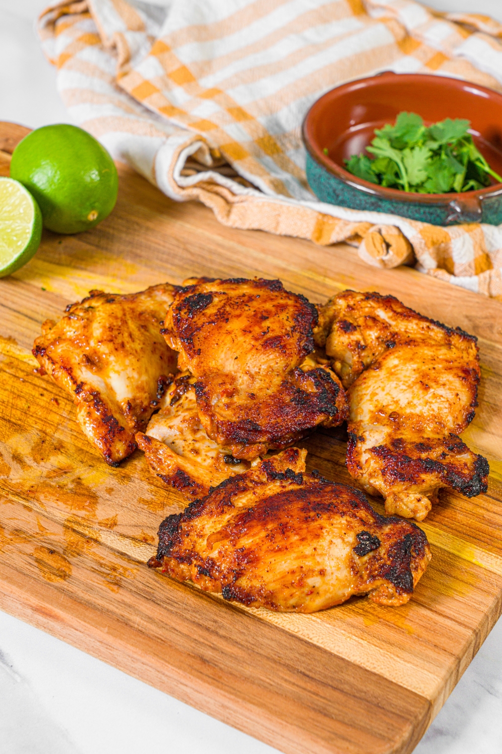 A bunch of chipotle honey chicken thighs on a wooden board.