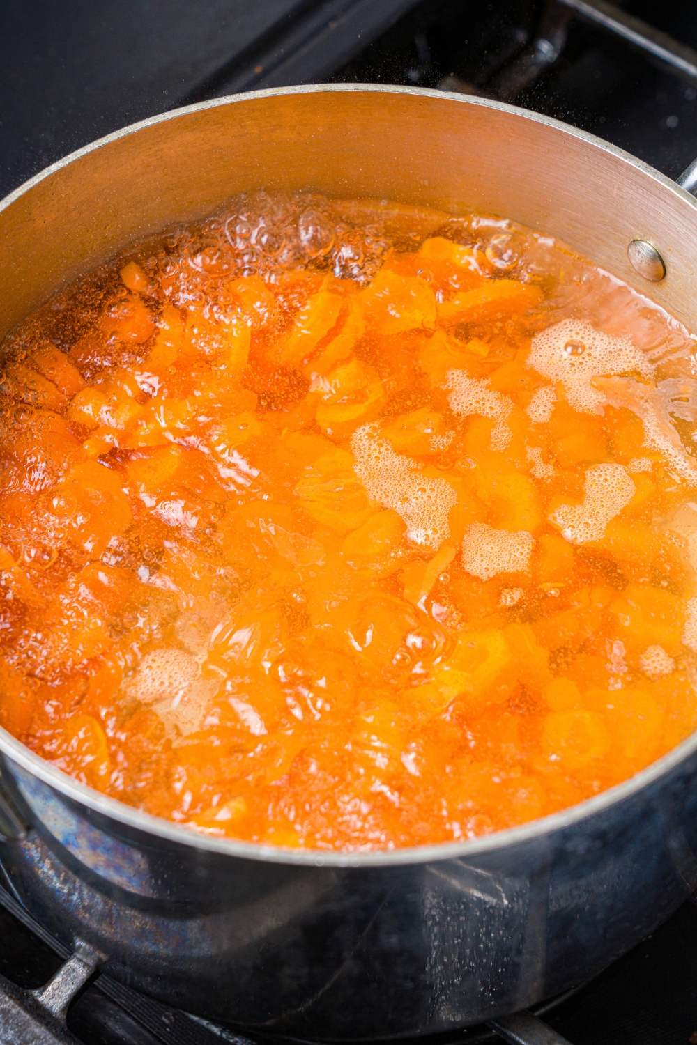 Diced carrots cooking in a pot of boiling water.