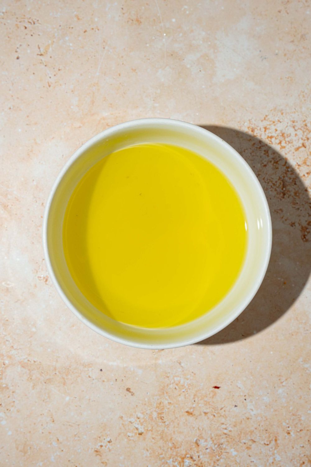 A large bowl of pickle juice brine. The bowl is on a tan counter.