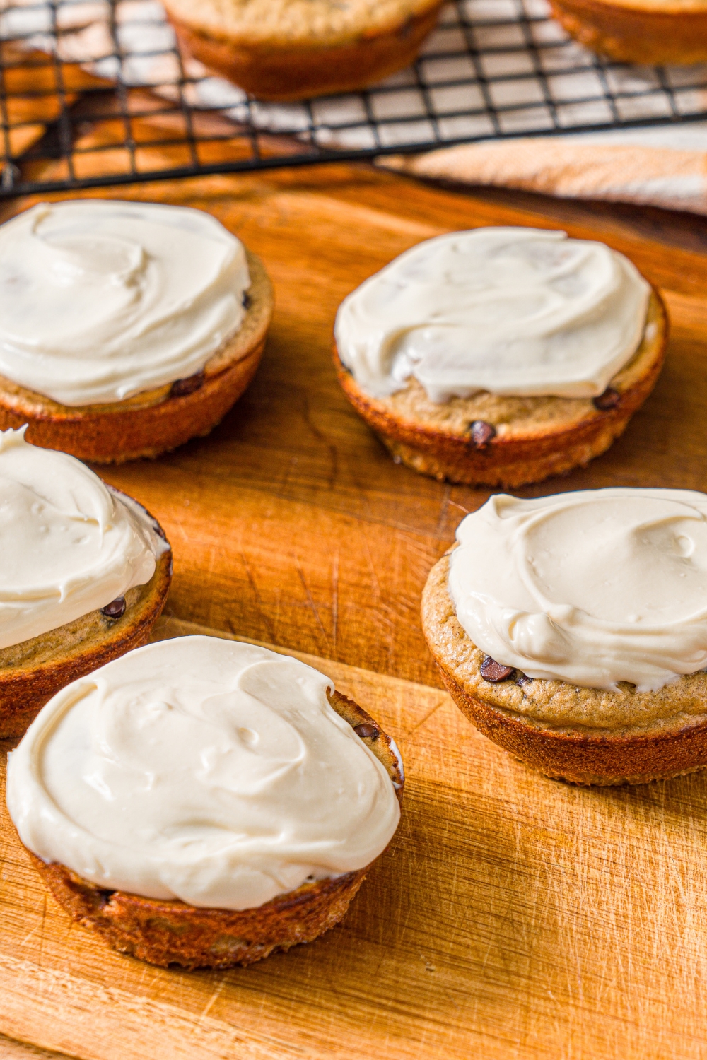 A wooden board with frosted protein banana muffins.