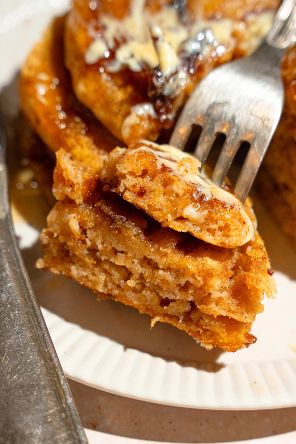 A fork of pumpkin pancakes in front of a stack of the pancakes.