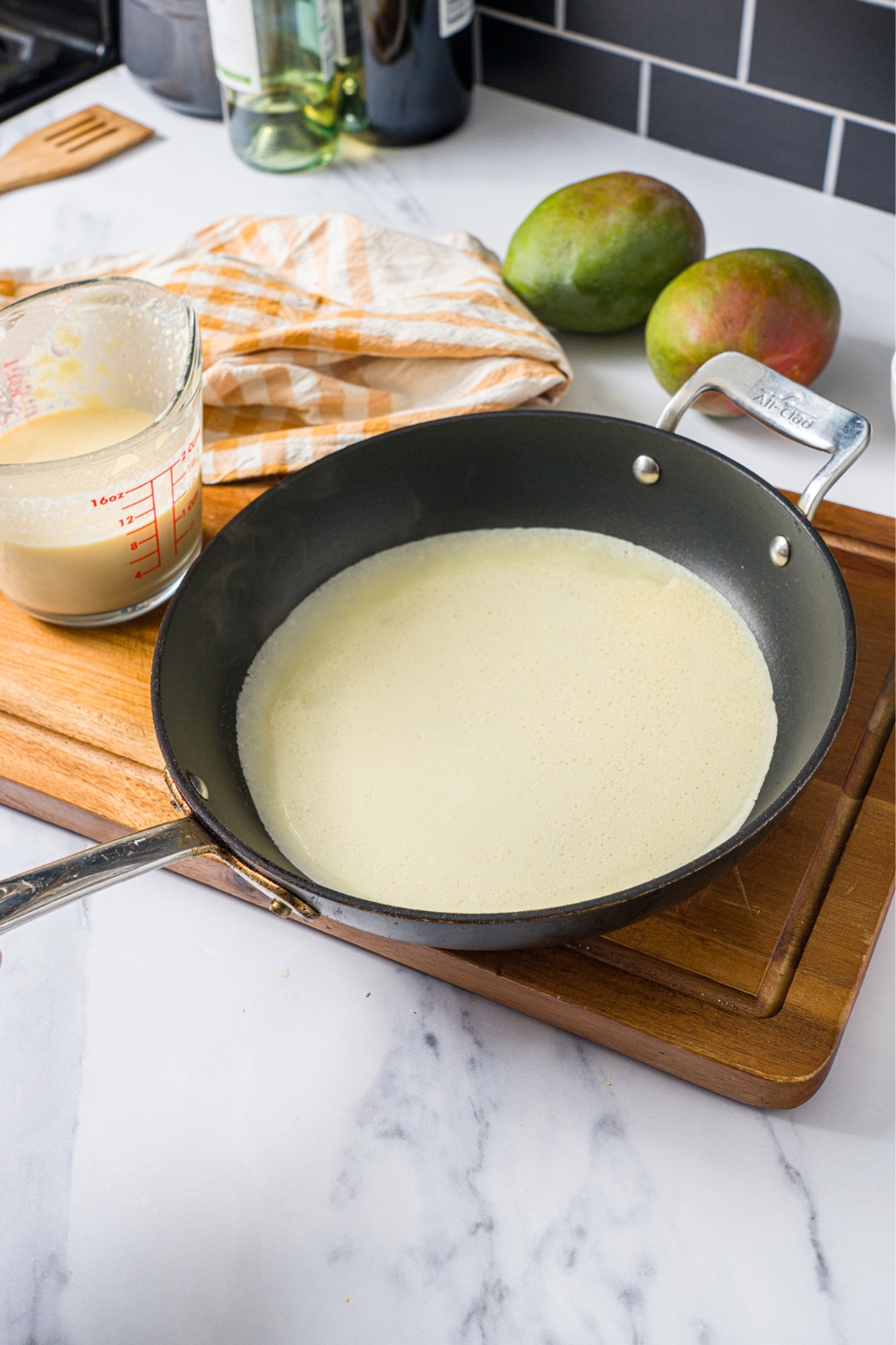 Mango pancake batter in a black skillet.