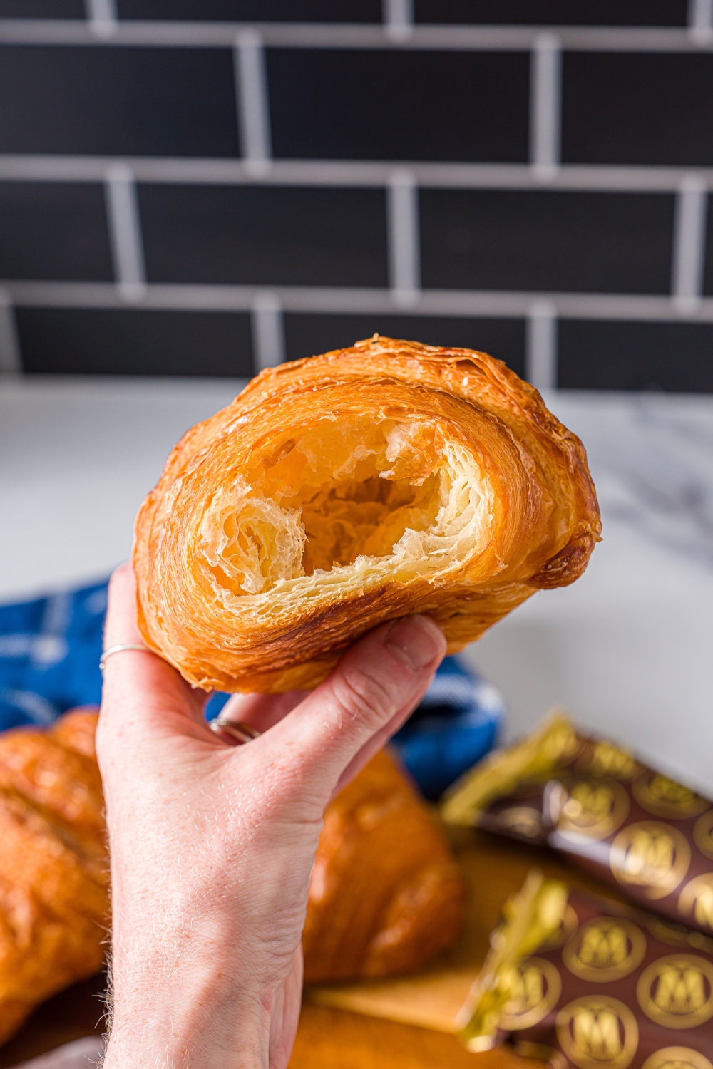 A hand holding a hollowed out croissant.