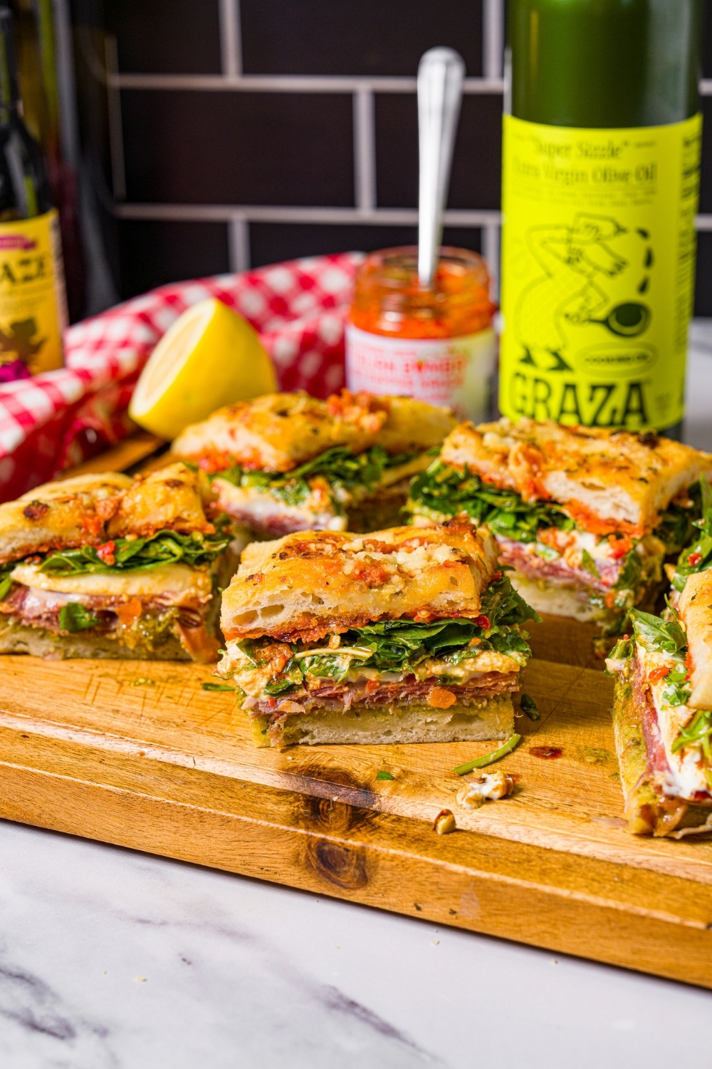 Four square squares of Trader Joe's focaccia sandwich and a wooden cutting board.