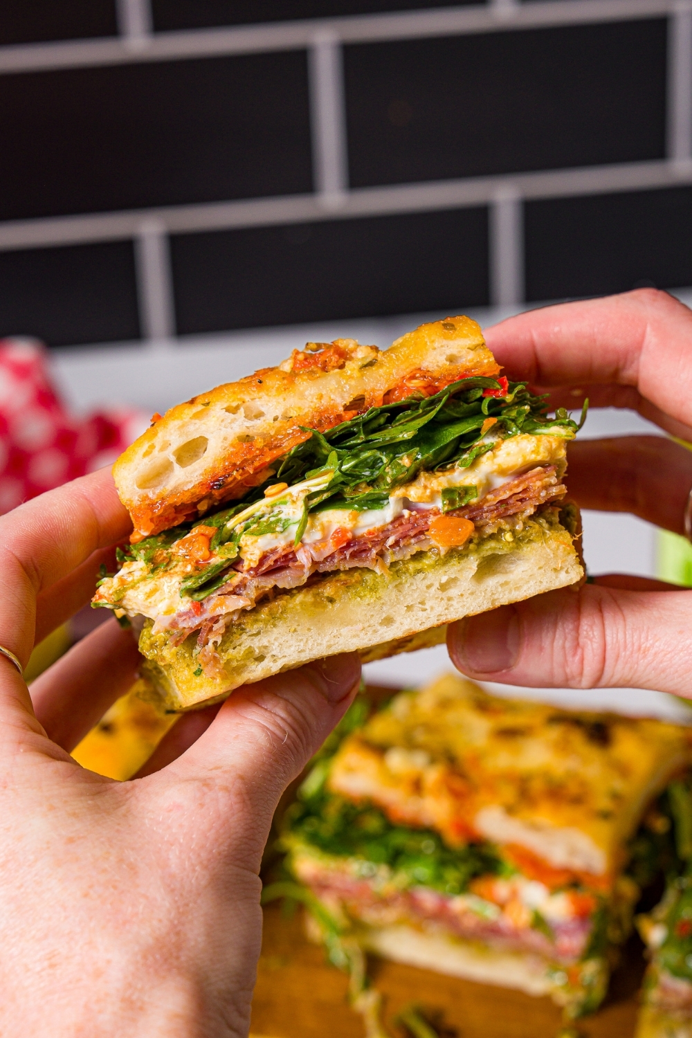 Two hands holding a square of the viral Trader Joe's for focaccia sandwich.