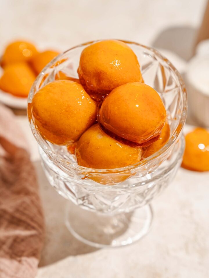 Four bala baiana overlapping one another in a glass bowl.