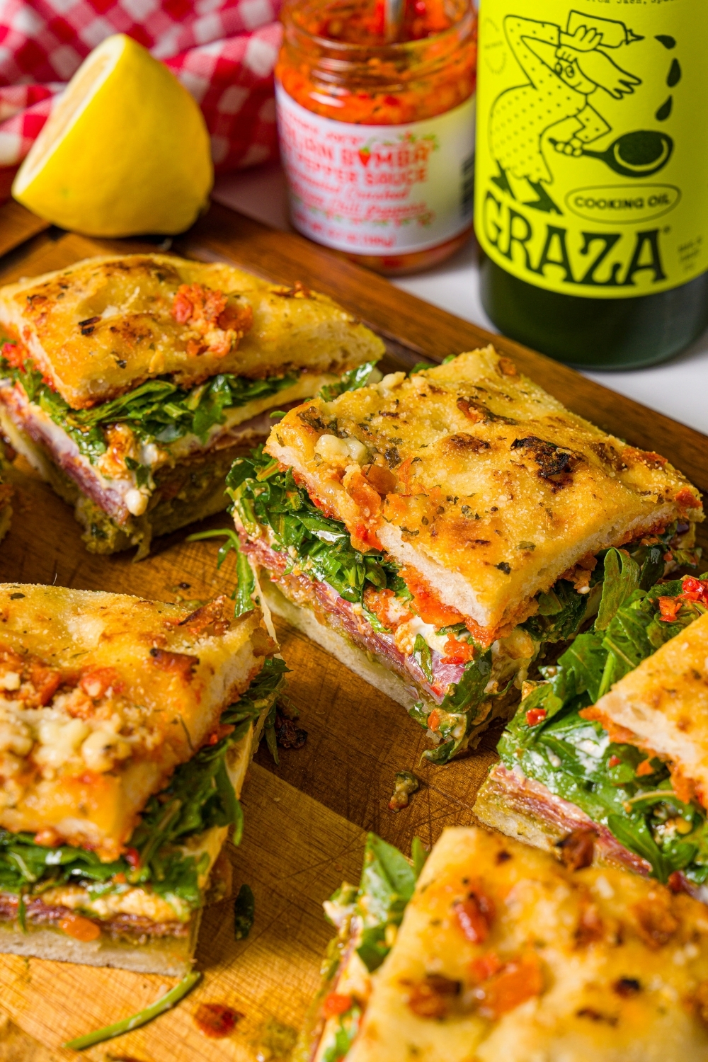 A bunch of squares of the viral Trader Joe's focaccia sandwich on a wooden cutting board.