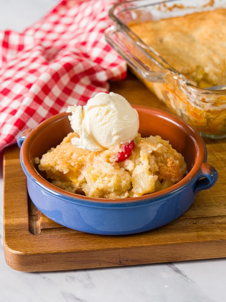 A bowl of cuppa cuppa cake with a scoop of ice cream on top in a glass bowl.