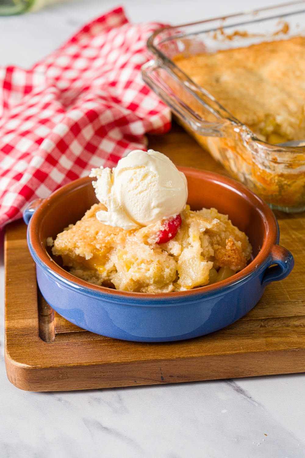 A bowl of cuppa cuppa cake with a scoop of ice cream on top in a glass bowl.