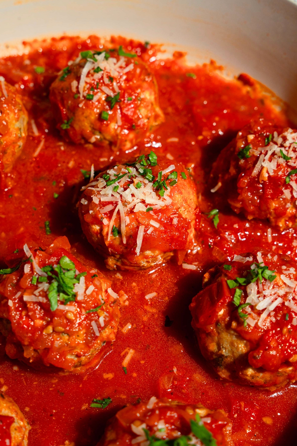 Five Hailey Bieber chicken meatballs and tomato sauce in a pot.