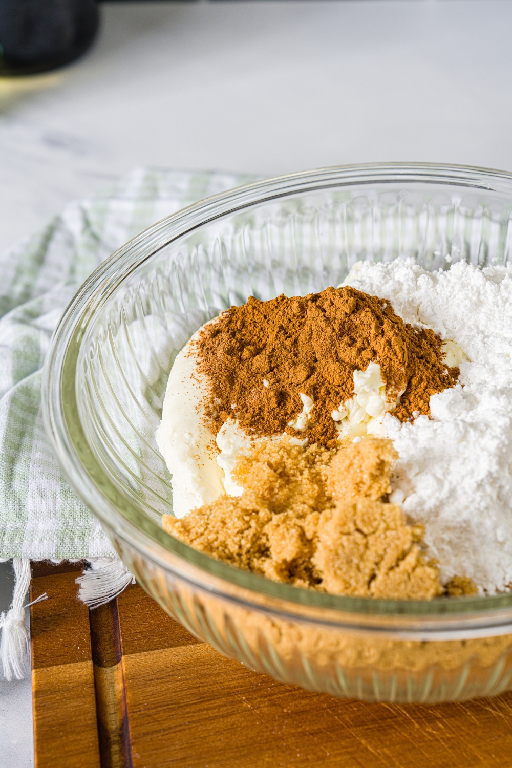 A glass bowl with powdered sugar, cinnamon, brown sugar.