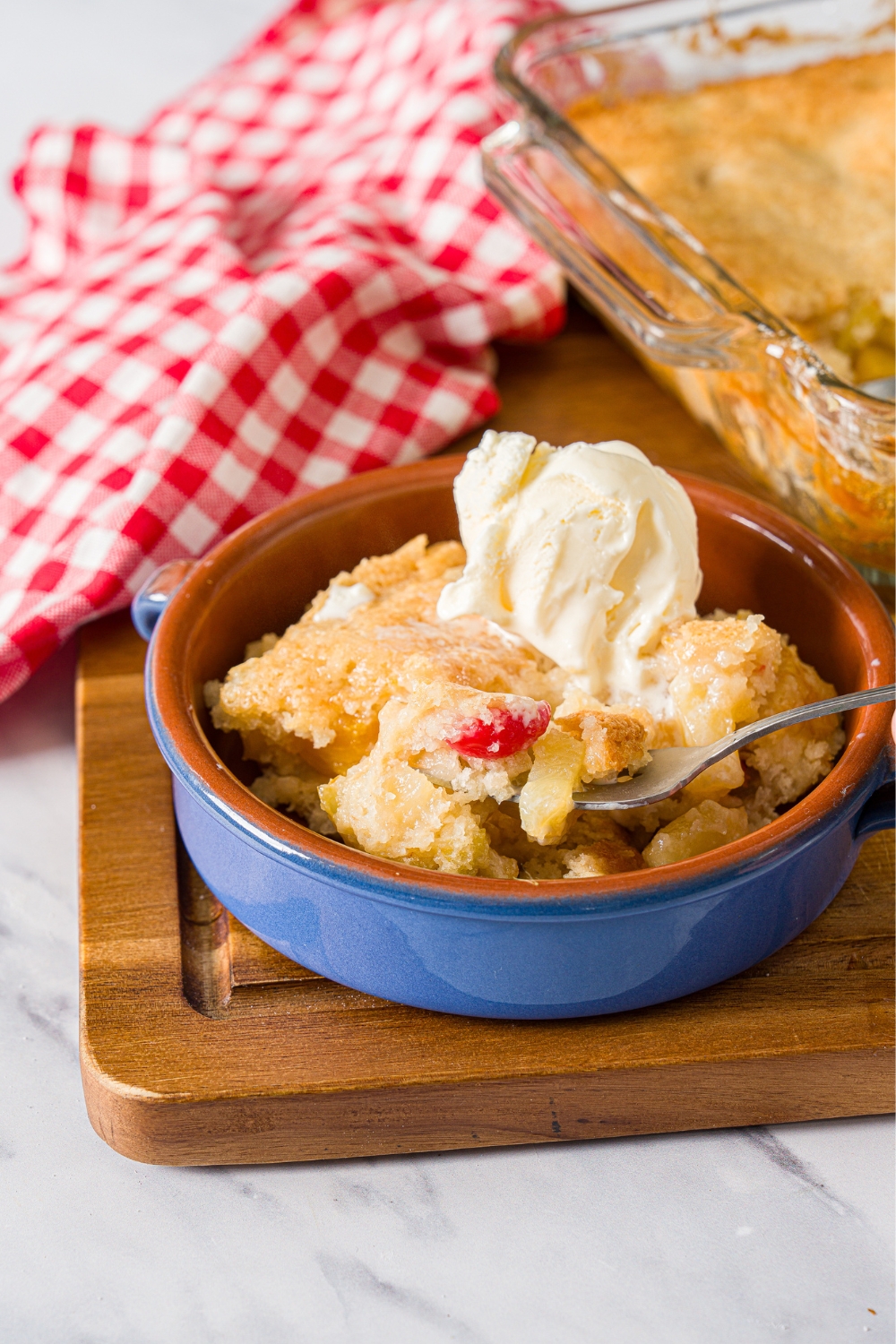 A spoon submerged in cuppa cuppa cake in a bowl that is filled with the cake.