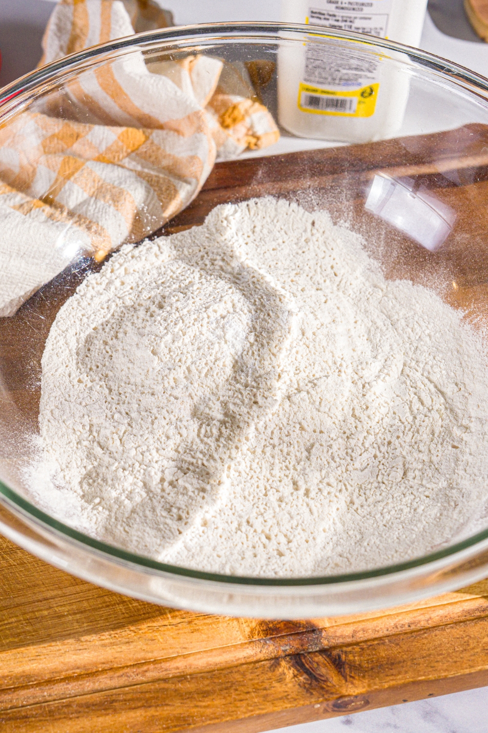 A large bowl with a dry ingredient mixture to make Hardee's biscuits. The bowl is on a wooden board.
