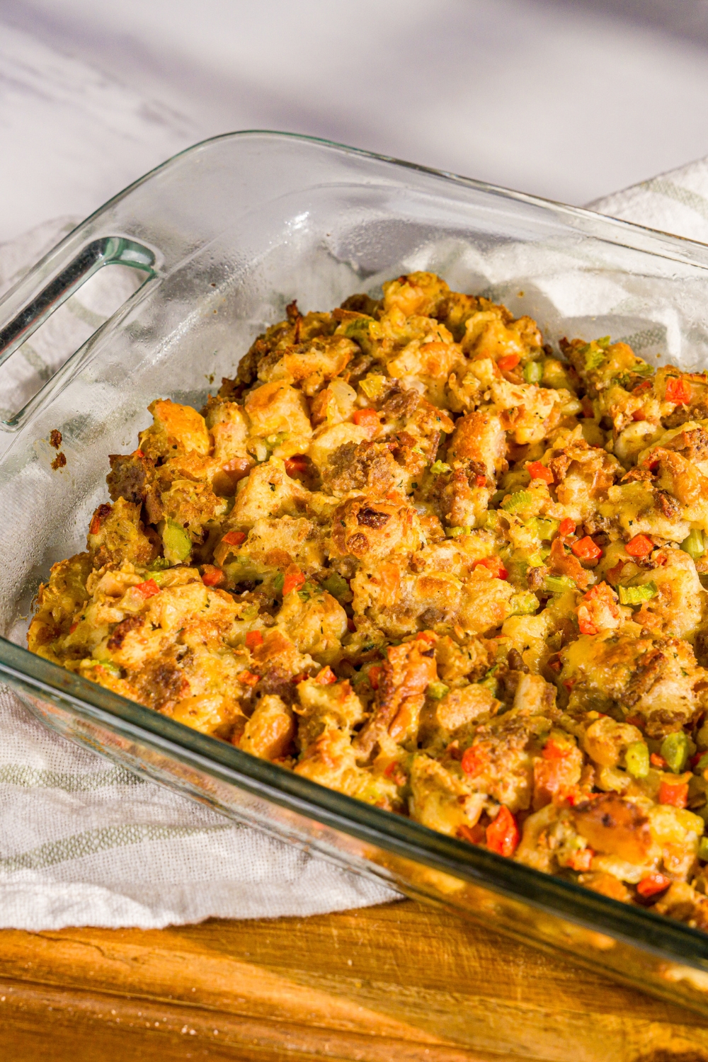 A baking dish with baked White Castle stuffing. The dish is on a wooden board.