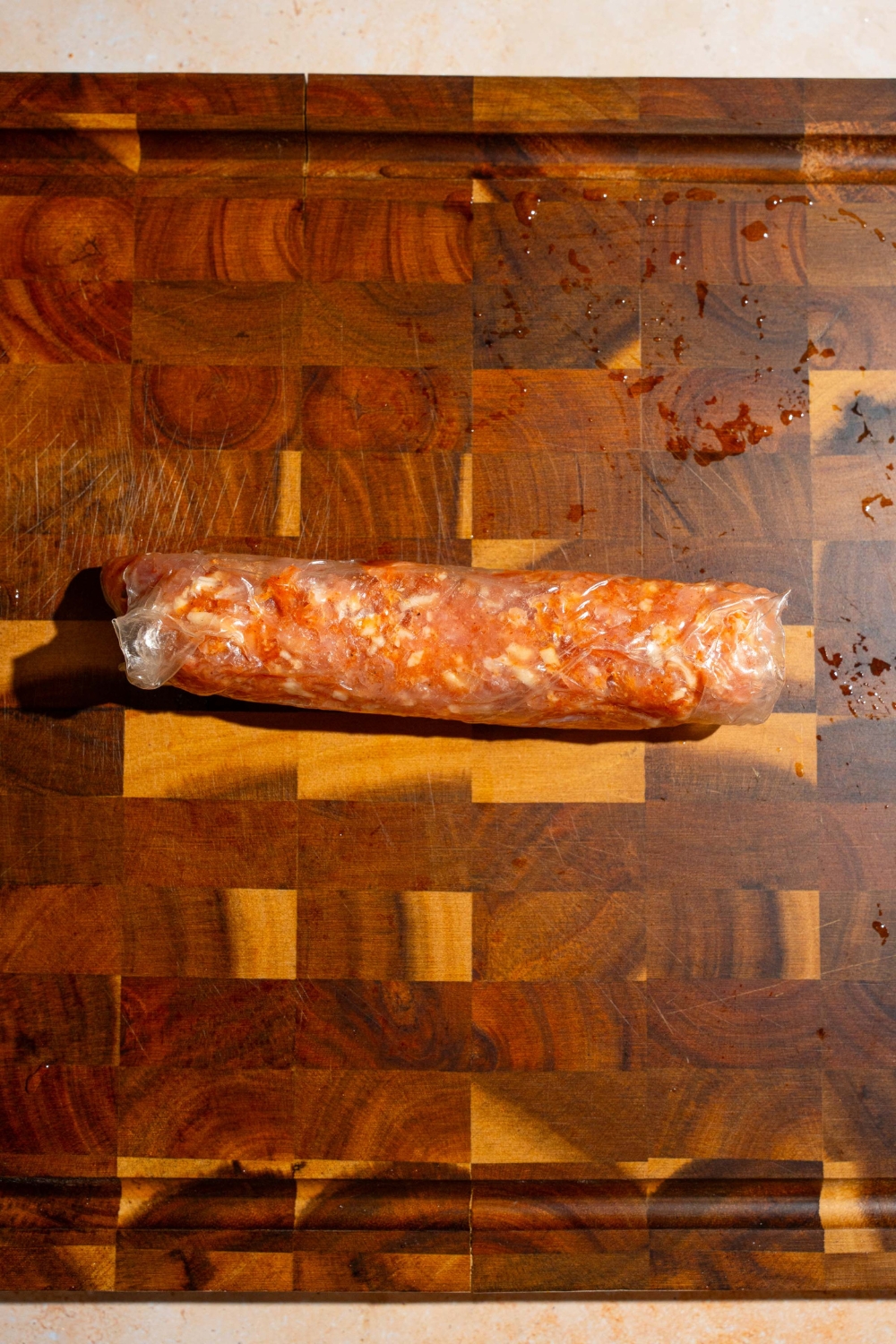 A wooden board with a rolled rice paper chicken wrap.