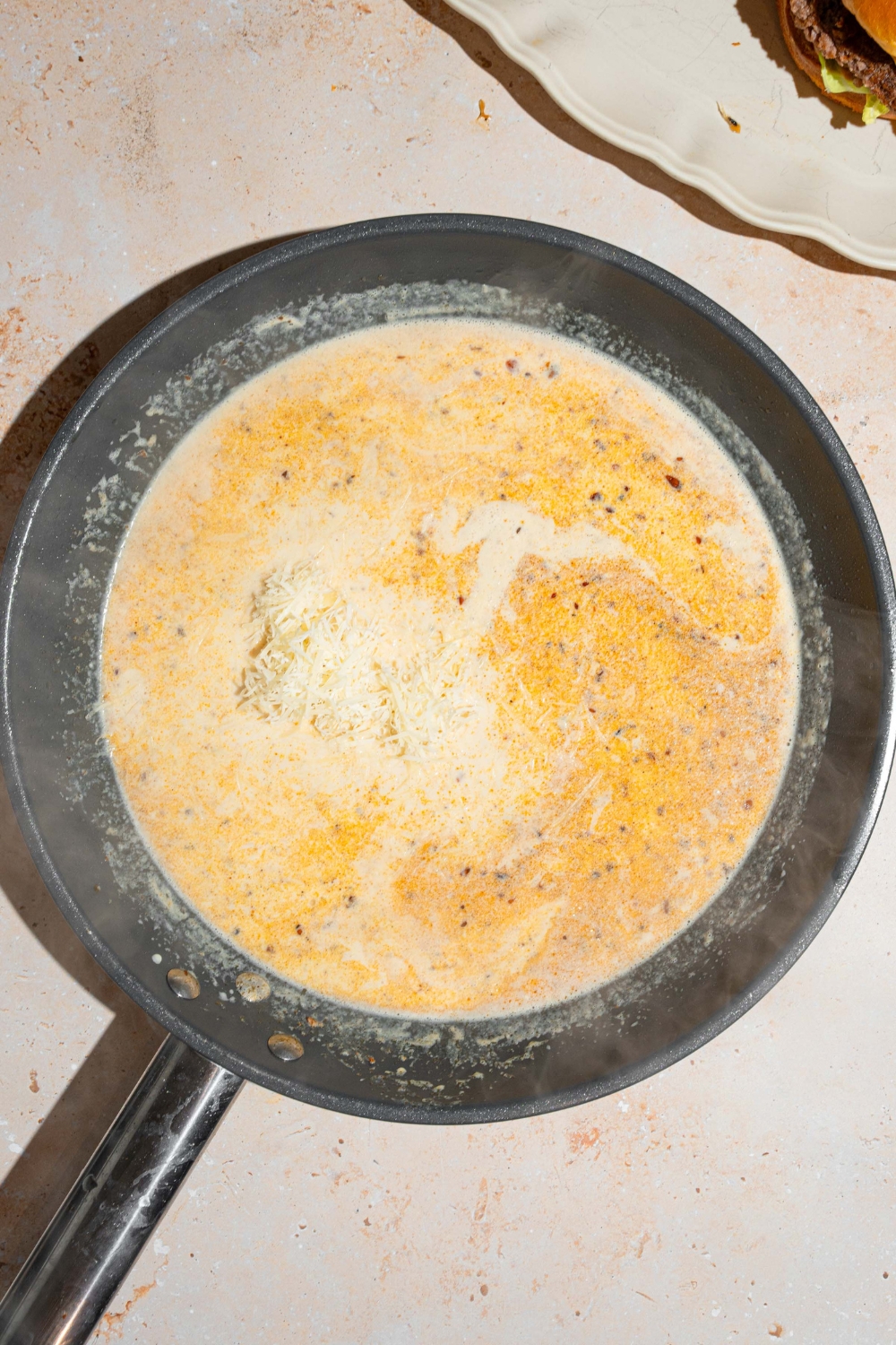 A skillet that is filled with a garlic Parmesan dipping sauce, cooking in it.