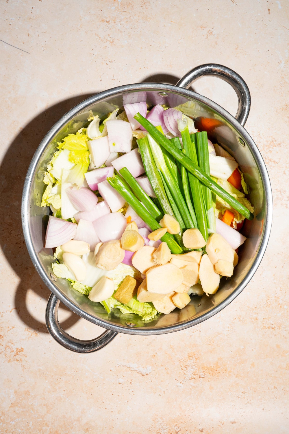 Chopped onion, celery, scallions, carrots, and garlic in a large pot.